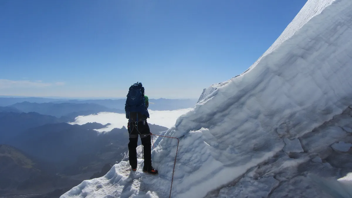 Photo of team member crossing crevasse around difficult edge